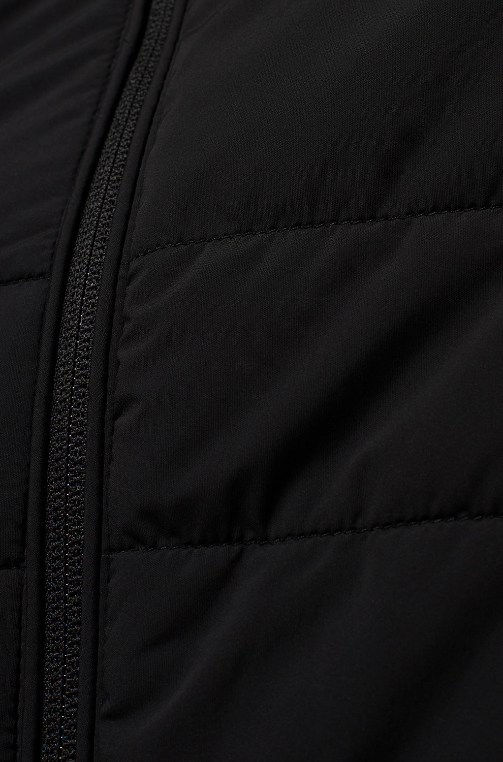 Gros plan du coupe-vent mi-saison noir avec fermeture éclair et tissu matelassé pour homme par Psycho Bunny