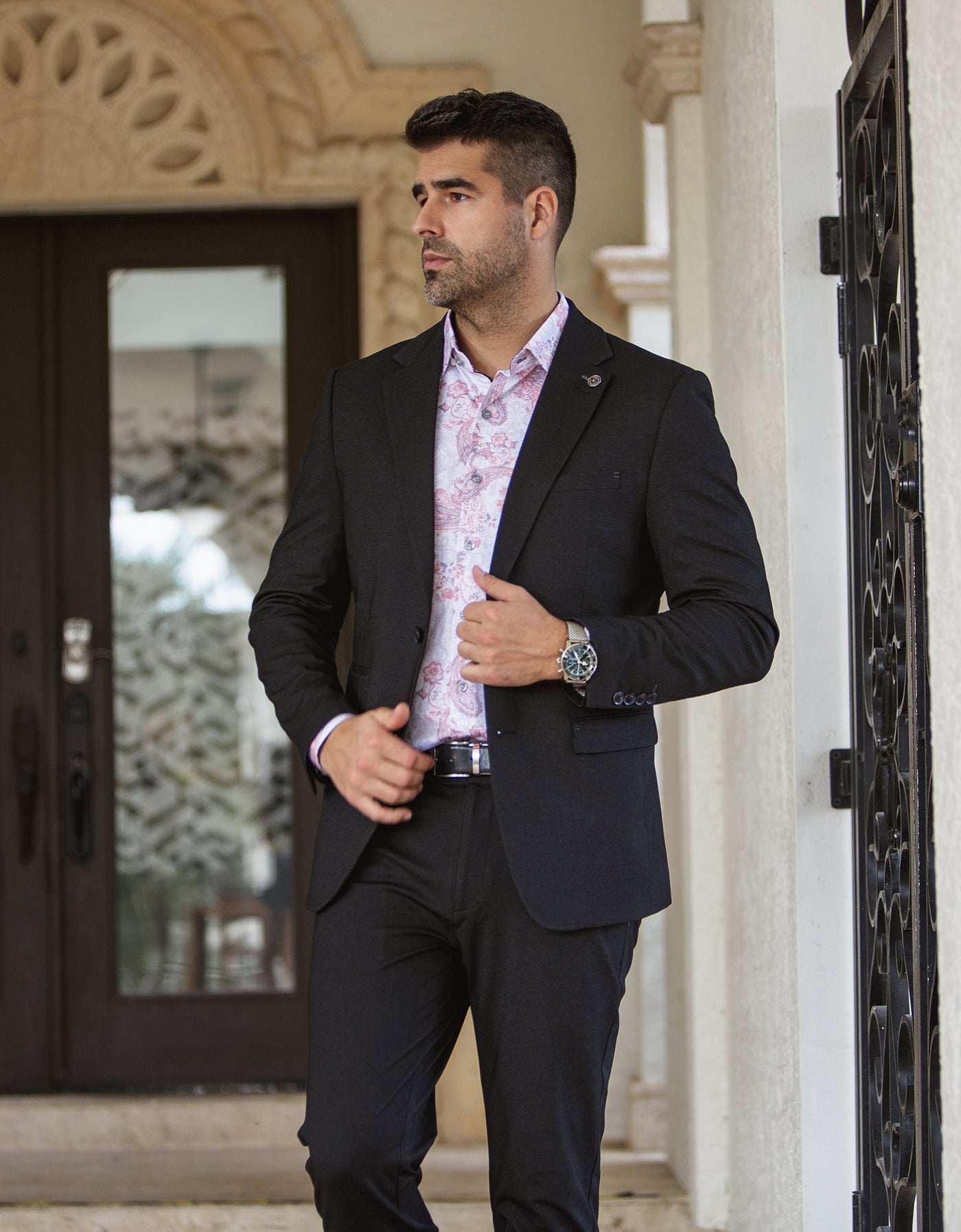 Veston noir Au Noir pour homme avec chemise rose à motif paisley et pantalon noir, pour un look habillé de mode masculine.