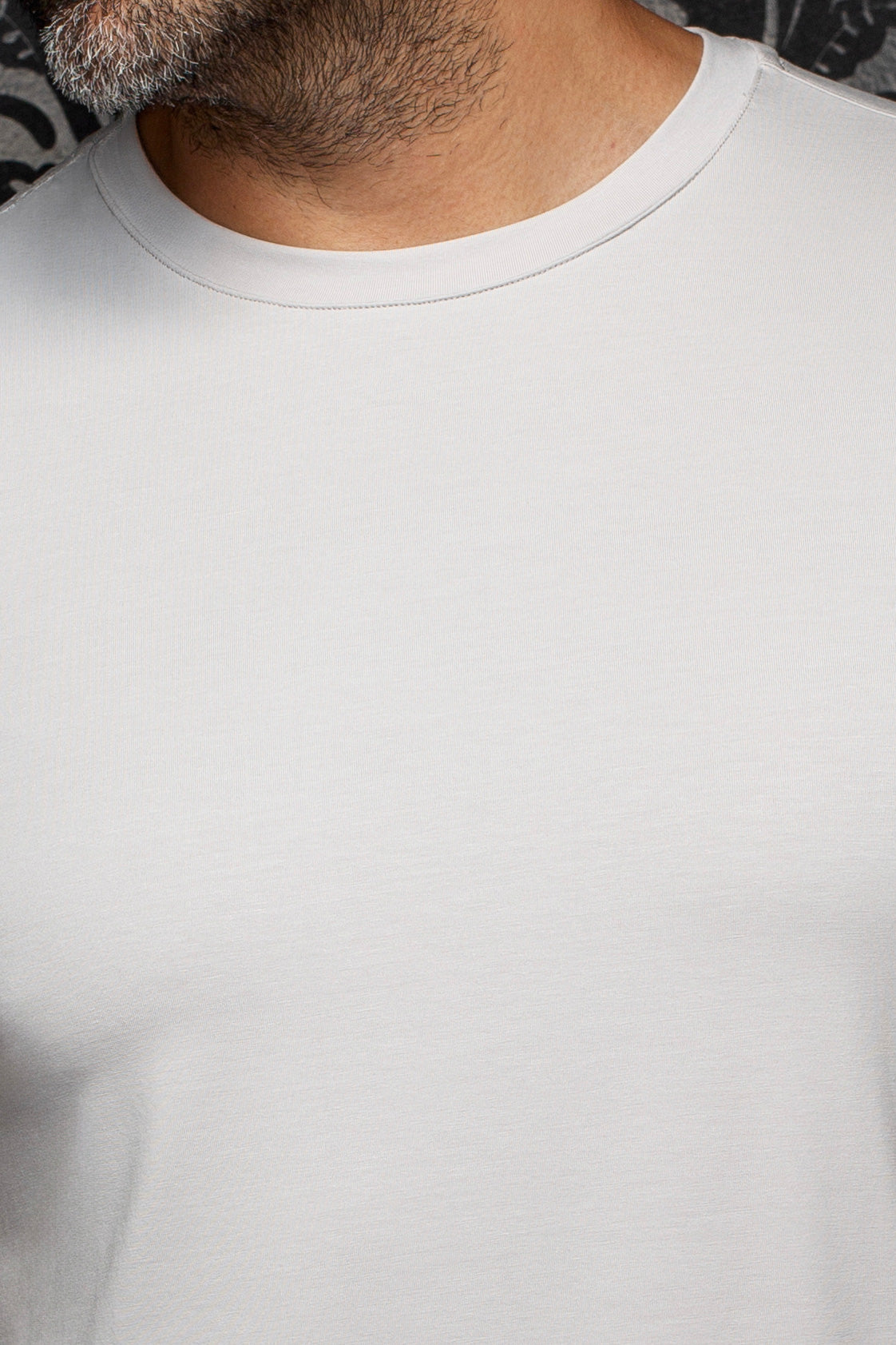 Détail rapproché d’un T-Shirt gris pâle à col rond côtelé et texture jersey lisse pour homme par Au Noir