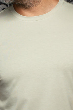 T-Shirt vert sauge pâle montrant col côtelé et texture jersey fine pour homme par Au Noir, en gros plan