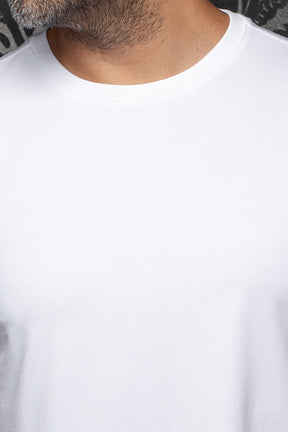 Détail du col rond d’un T-Shirt blanc uni, montrant l’encolure cousue et le jersey lisse pour homme par Au Noir