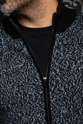 Gros plan de la veste en cachemire zippée en tricot chiné avec col côtelé noir et fermeture éclair pour homme par Au Noir