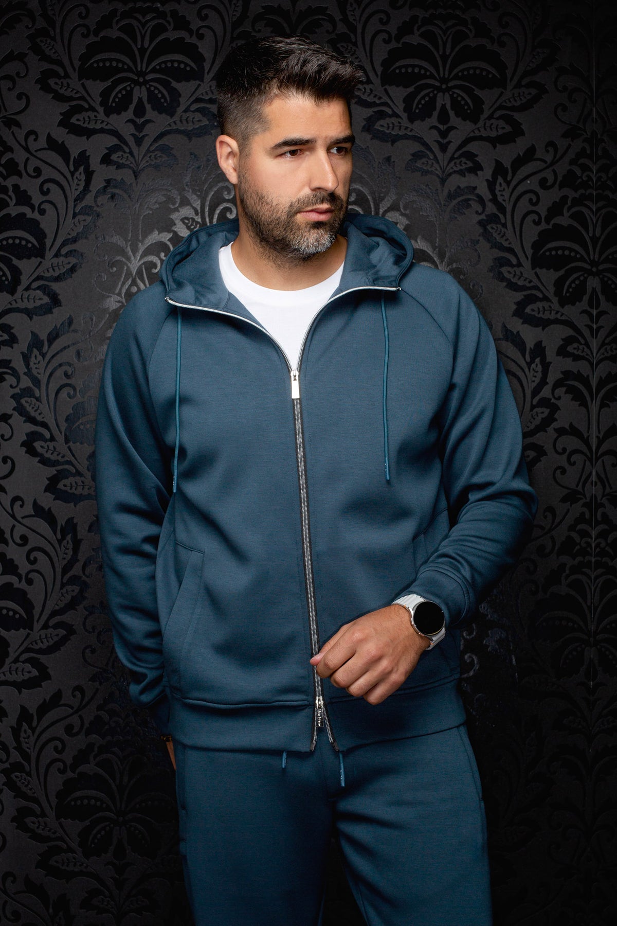 Veste sport à capuchon sarcelle zippée sur modèle, vue de face avec cordons et poches pour homme par Au Noir