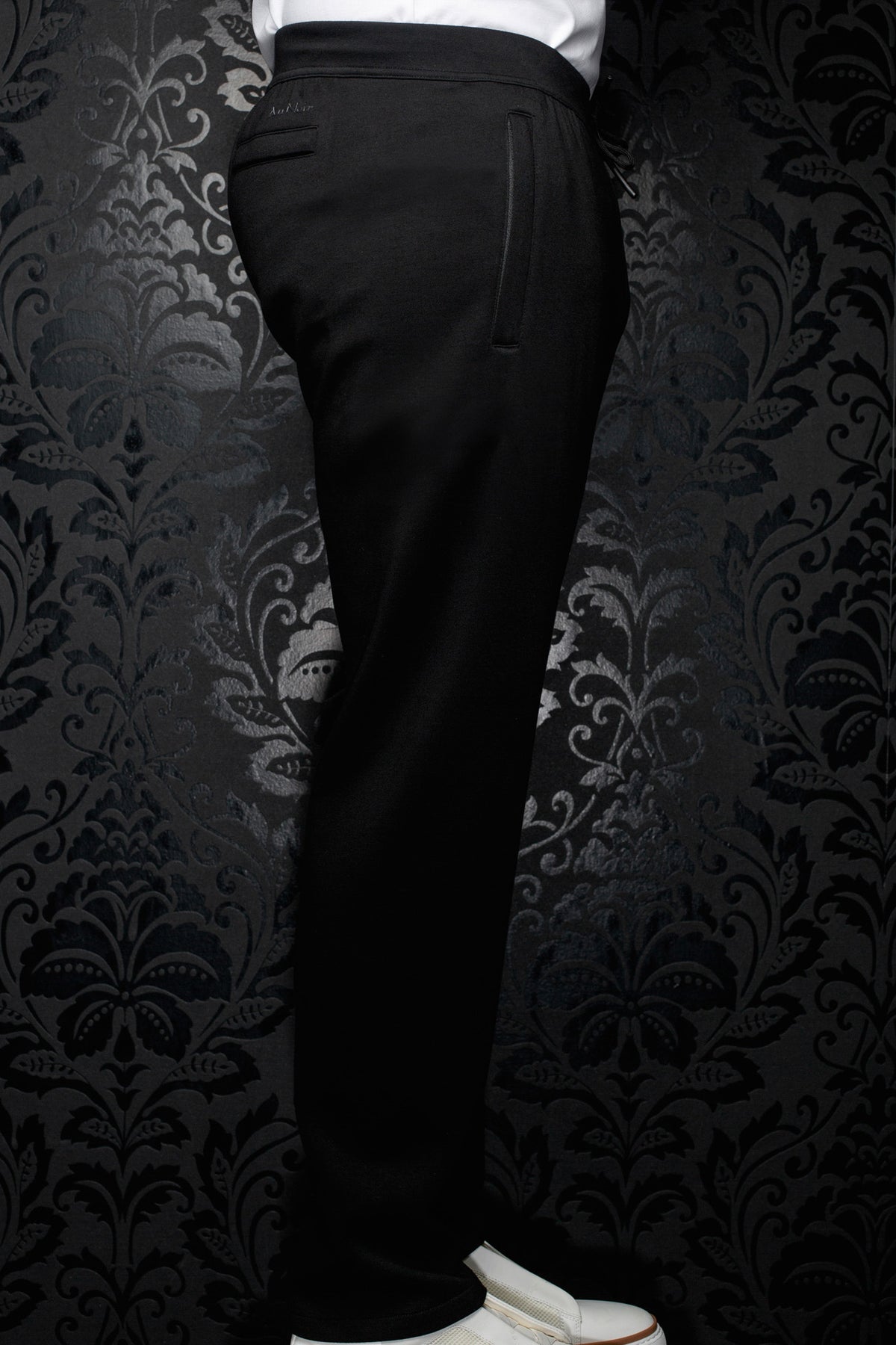 Vue de côté du pantalon jogging noir avec taille élastique, cordon et poche verticale pour homme par Au Noir