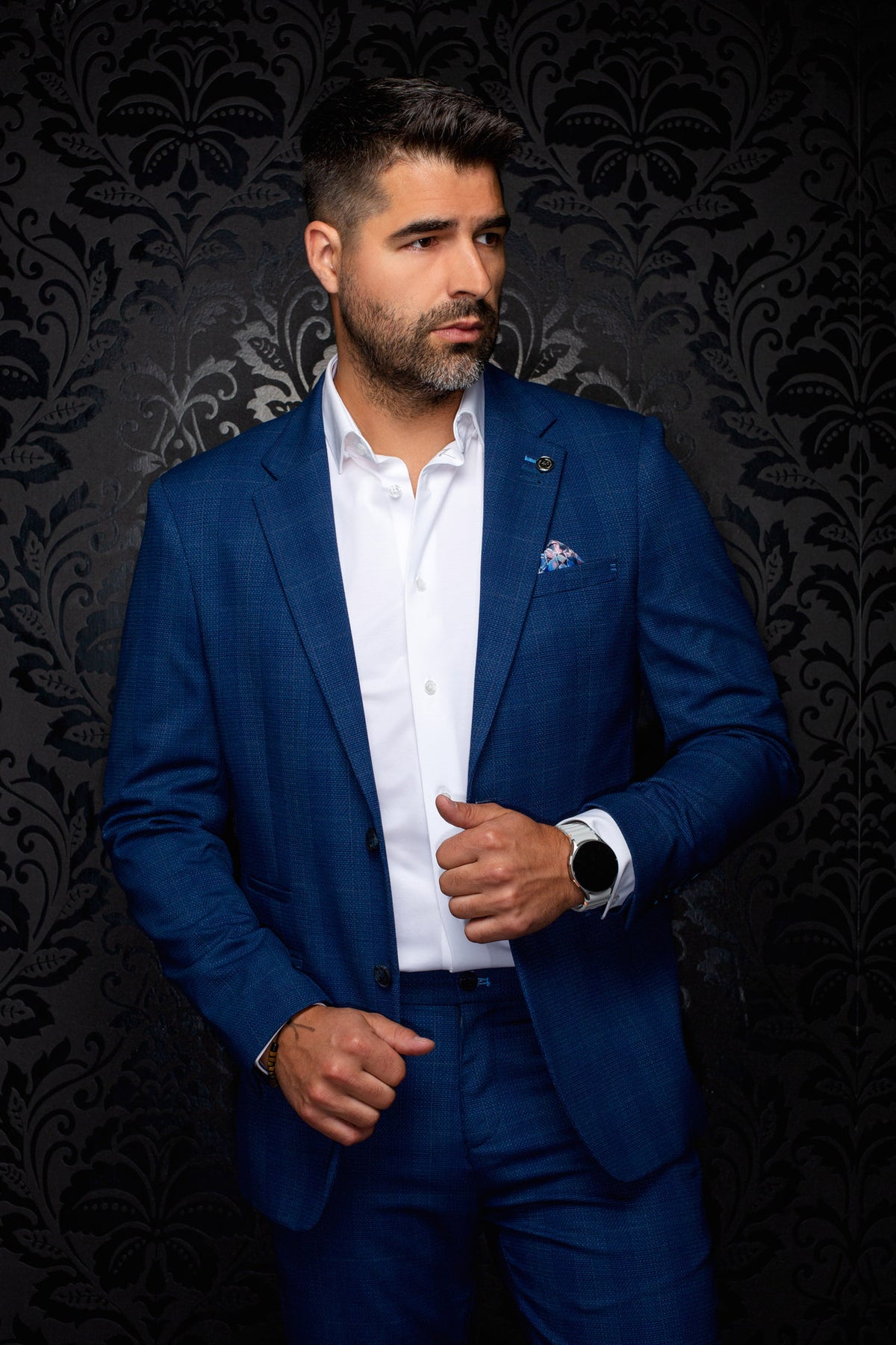 Veston bleu texturé avec revers crantés, poches à rabat et épinglette pour homme par Au Noir, vue de face sur mannequin