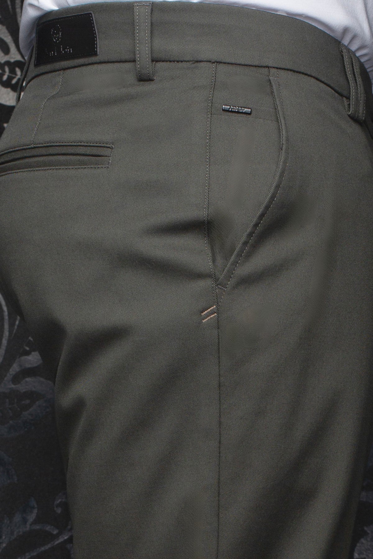 Pantalon chino vert olive avec passants, poche passepoilée et garnitures logo pour homme par Au Noir, en gros plan