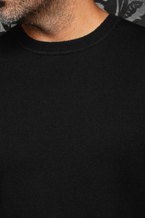 Chandail en cachemire noir en tricot fin avec col rond côtelé et devant uni pour homme par Au Noir, en gros plan