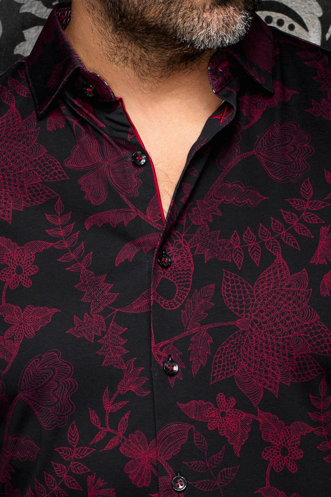 Col de chemise noire, imprimé floral bourgogne, boutons lustrés et bordure rouge pour homme par Au Noir, en gros plan