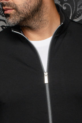 Col montant noir et fermeture argentée entrouverte sur une veste sport blanc pour homme par Au Noir, en gros plan