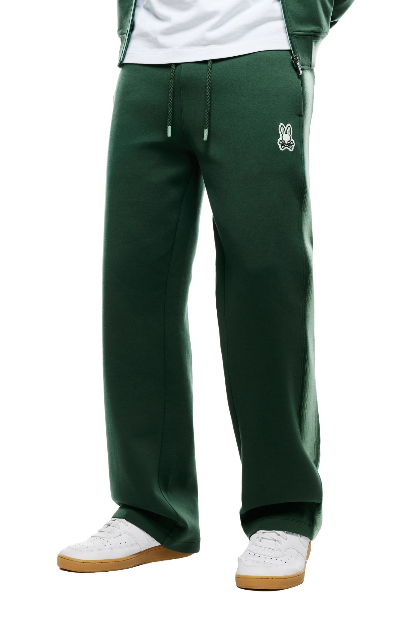 Psycho Bunny men's dark green sweatpants with wide open hems, logo patch and drawstring waist, front model view