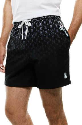 Men's close front view of black swim shorts showing hem patch, side logo tag and white drawstring by Psycho Bunny