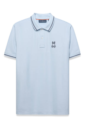 Vue de face d’un polo bleu pâle avec col et poignets rayés, patte boutonnée et logo poitrine pour homme par Psycho Bunny