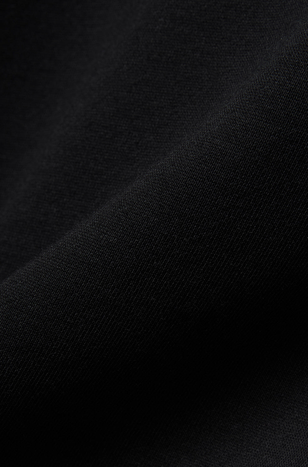 Psycho Bunny men's close-up detail of black knit sweatshirt fabric showing a smooth textured surface