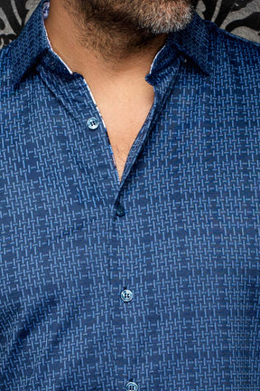 Détail serré du col et de la patte d’une chemise bleue à motif géométrique et boutons bleus pour homme par Au Noir