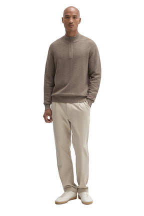 Men's full-length front view of taupe quarter-zip knit long-sleeve knit sweater styled with light pants by Robert Barakett