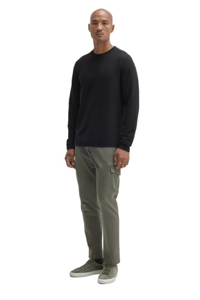 Men's full-body angled view of black long sleeve crew neck T-Shirt styled, front model view by Robert Barakett