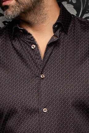 Gros plan d’une chemise noire à micro-motif géométrique avec col ouvert et boutons pâles pour homme par Au Noir