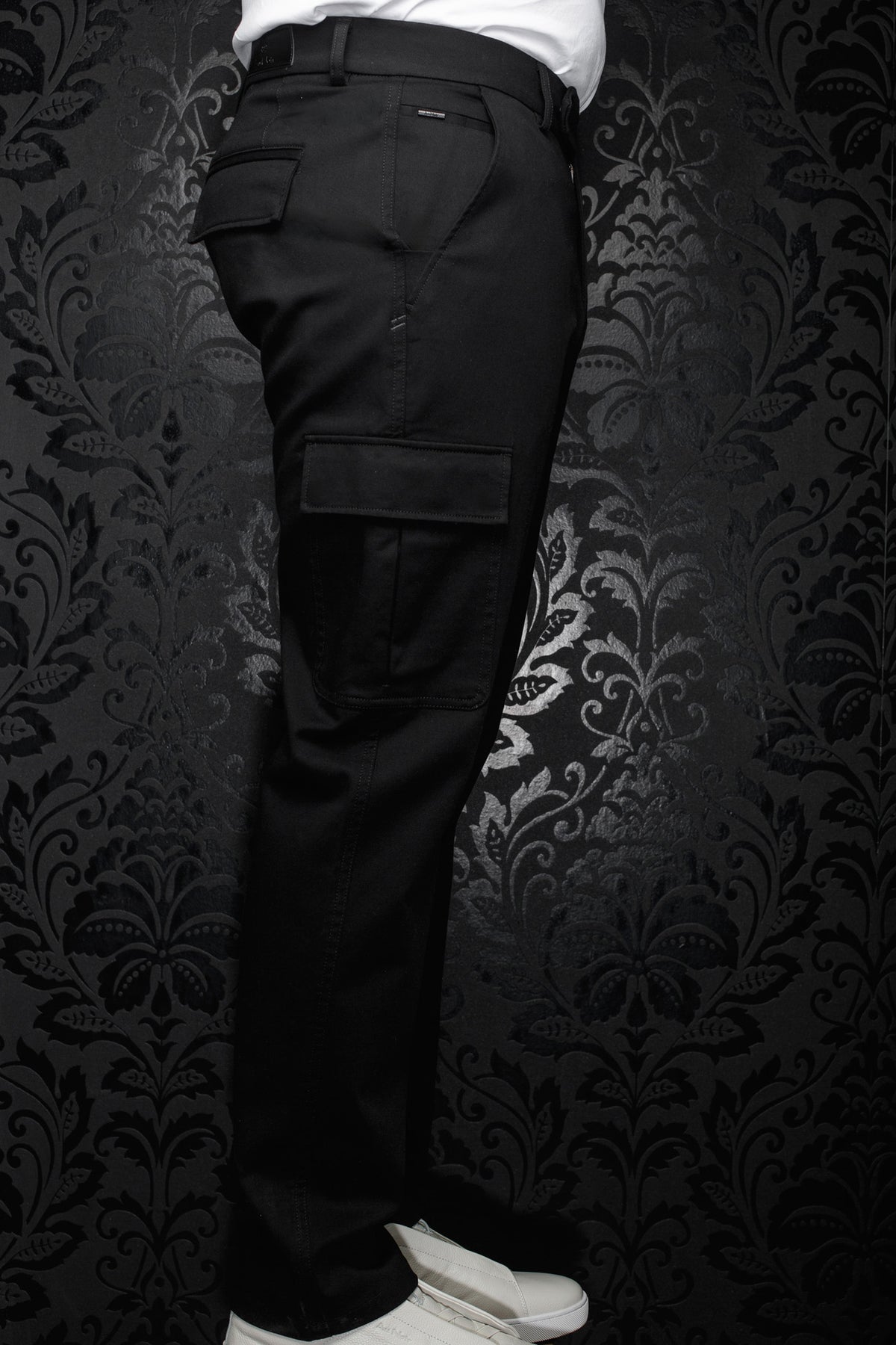 Pantalon cargo noir avec poche à rabat, passants et petite étiquette métal pour homme par Au Noir, vue de côté