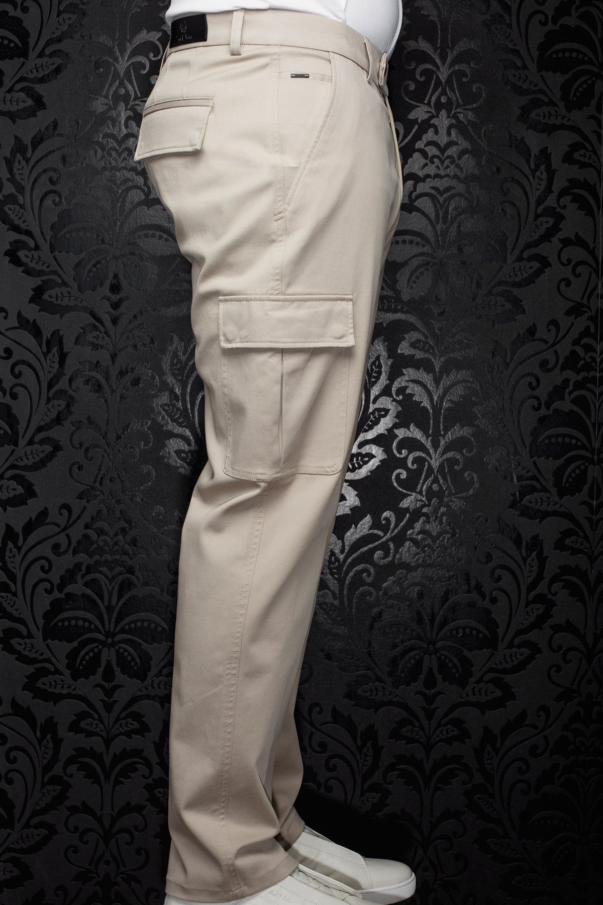Pantalon cargo beige vu de côté, avec poches à rabat, passants et jambe droite pour homme par Au Noir