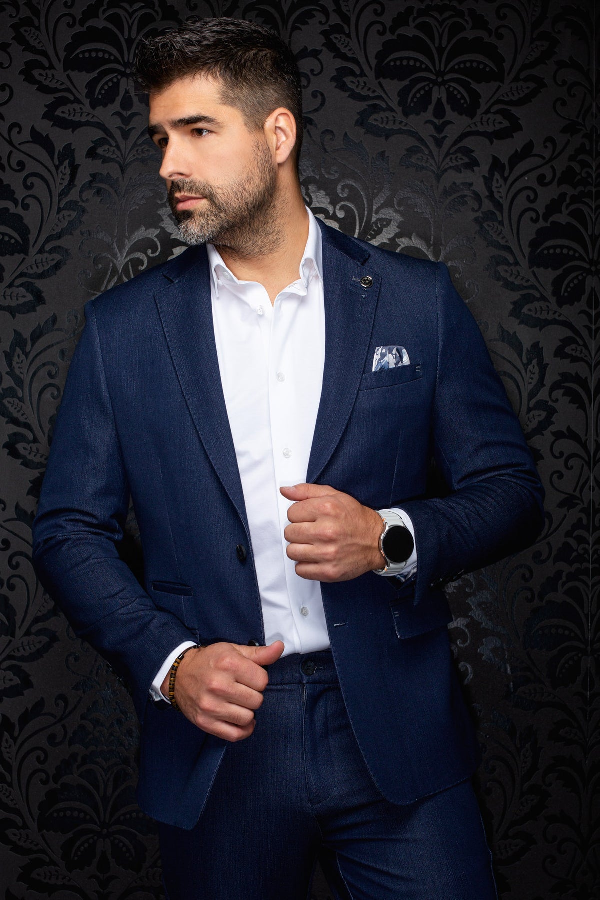 Veston bleu marine sur mannequin, vue avant de biais avec revers crantés, pochette et poches à rabat pour homme par Au Noir