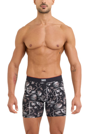Front model view of men's black hockey-print boxer underwear with SAXX logo waistband and pouch