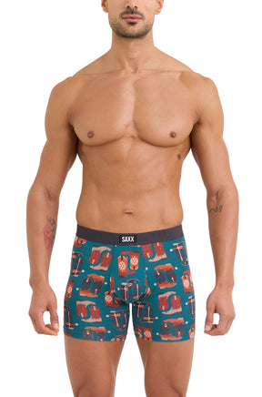 Men's teal boxer underwear with black SAXX logo waistband and western boot print, front model view