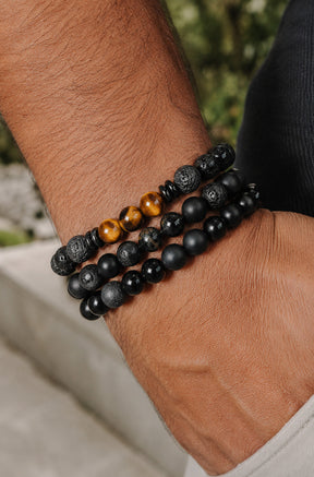 Bracelet noir à billes porté empilé au poignet avec d’autres bracelets à billes pour homme par Au Noir, détail
